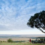 Maasai man overlooking vast plains of the Masai Mara